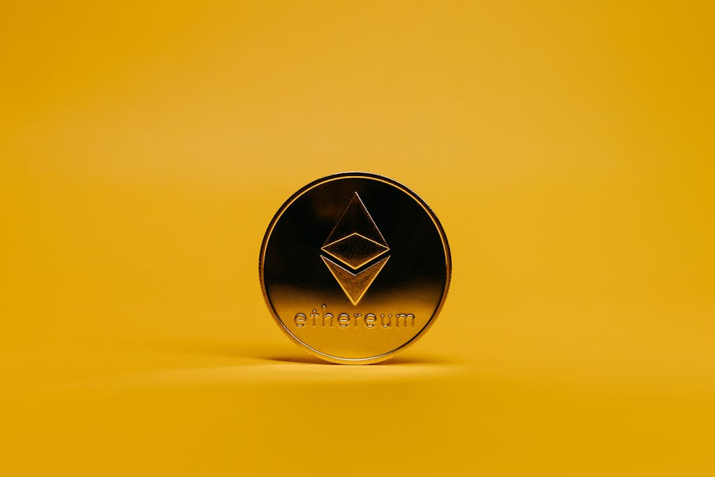 A shiny Ethereum coin displayed on a vibrant yellow background, symbolizing cryptocurrency.